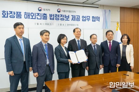이완규 법제처장(좌 4번째)과 오유경 식약처장(좌 3번째)이 업무협약서를 들어보이고 있다.<br>
