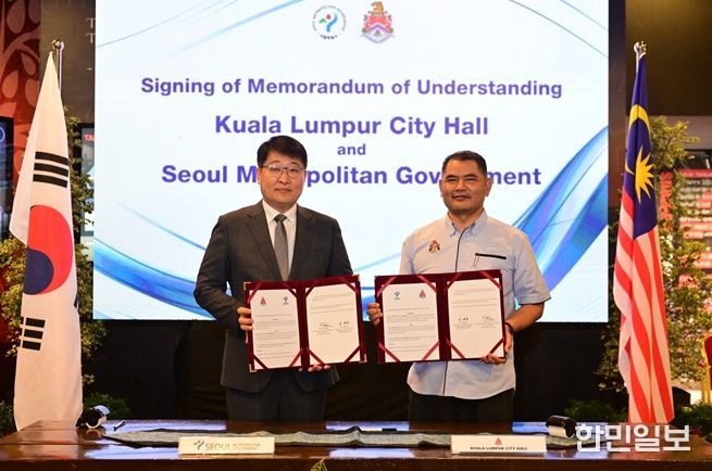 MOU 서명판을 들고 기념촬영 중인 (좌) 김태균 행정1부시장 (우) 이스마디 쿠알라룸푸르 부시장