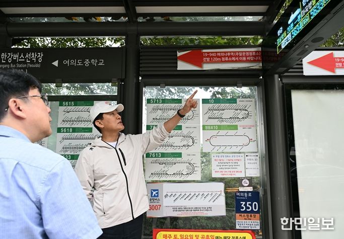 오세훈 서울시장이 18일 오전, 한강버스 여의도선착장 인근 버스정류장을 찾아 한강버스 안내 시스템을 확인하고 있다.
