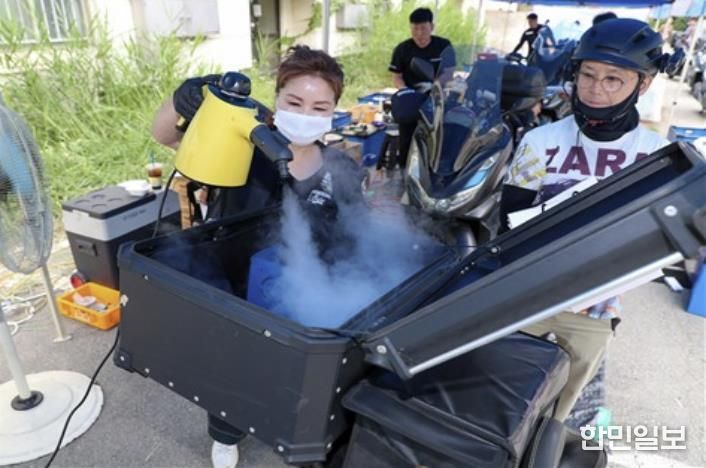 상반기 배달이륜차 무상 안전점검 행사에서 배달통 소독 서비스를 제공하고 있다