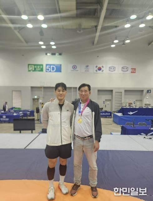 레슬링부 윤창희 감독과 김현우 선수가 기념사진을 찍고 있다.