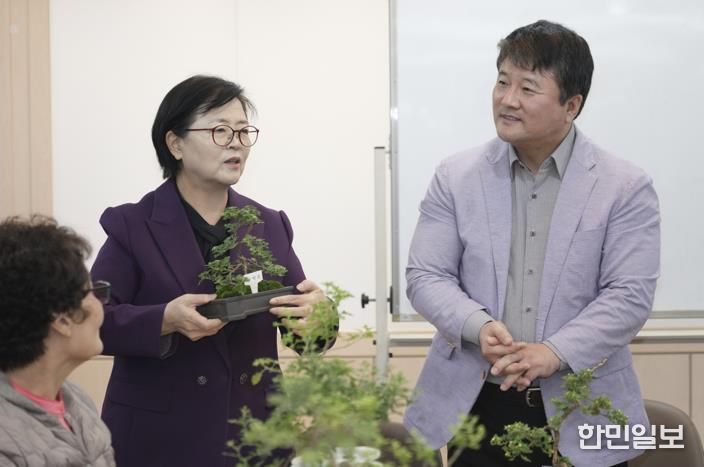 이순희 강북구청장(왼쪽 첫 번째)이 화계중학교를 방문해 최중호 교장과 함께 평생학습 프로그램 ‘국화분재 수업’에 참여한 주민들과 대화를 나누고 있다.