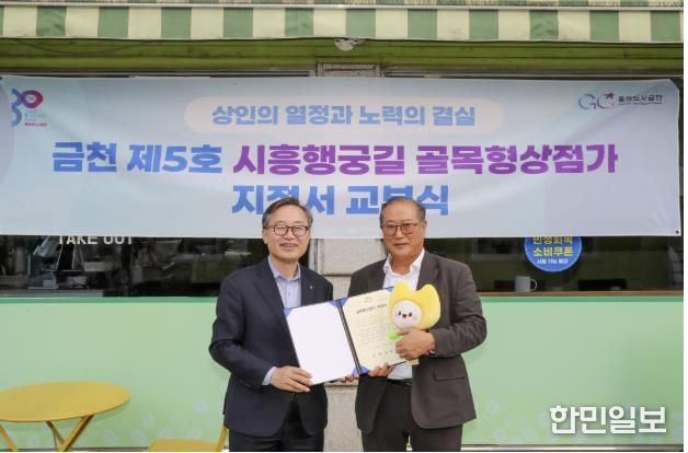 유성훈 금천구청장(왼쪽)과 김명식 상인회장이 골목형상점가 지정서 교부식을 진행하고 기념촬영을 하고 있다