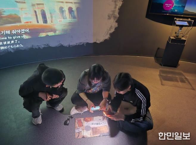참여자들이 스마트기기와 실물 단서를 활용해 미션을 해결하는 방탈출형 체험 콘텐츠 ‘용화향도 시즌2’의 한 장면