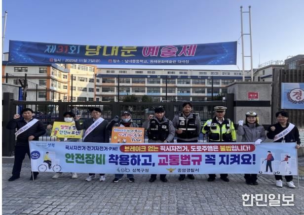 성북구·종암경찰서 관계자들이 학생들에게 자전거·PM 안전 이용 리플릿을 배부하고 있다.