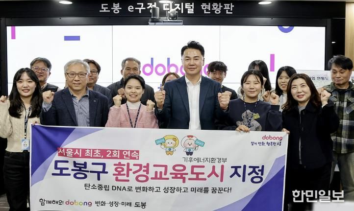 오언석 도봉구청장(가운데)이 환경교육도시 2회 연속 지정을 기념하며 직원들과 단체 사진을 찍고 있다