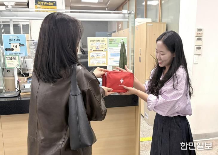 주민센터를 방문해 전입신고를 마친 청년에게 웰컴키트를 전달하고 있다