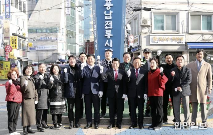 서강석 송파구청장(가운데)이 풍납시장 간판어닝 개선사업 준공현장에 방문해 주민들과 함께 기념촬영을 하고 있다