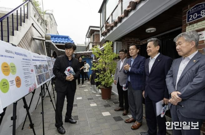 수원시와 한국보훈복지의료공단이 수원지역 독립유공자 후손의 집수리를 지원한 새빛하우스 앞에서 관계자들이 사업 설명을 듣고 있다.