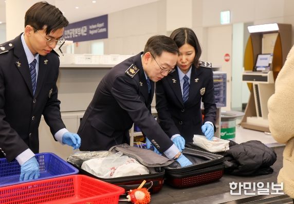 이명구 관세청장(가운데)이 22일 오전 인천국제공항 제1여객터미널에서 직접 여행자 휴대품을 검사하고 있다