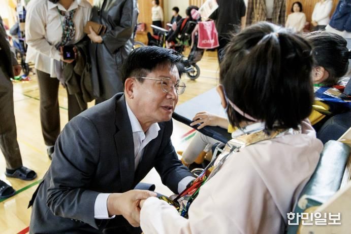 몸을 낮추고 한국우진학교 학생들과 인사를 하는 박강수 마포구청장