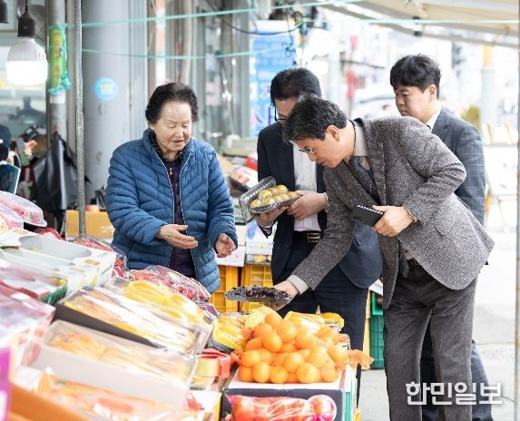 김돈곤 청양군수가 청양전통시장에서 과일을 고르며 농어촌 기본소득을 사용하는 모습
